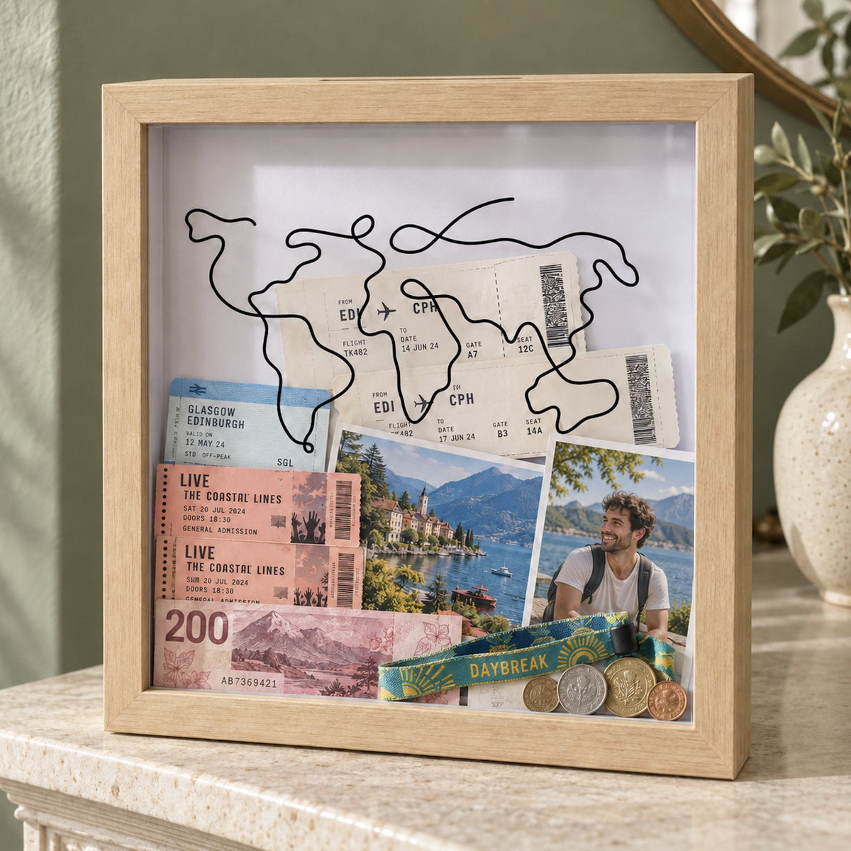 Natural wood Wandersake Memory Box on a stone mantelpiece, holding Edinburgh to Copenhagen boarding passes, a photo of an Italian lake and a festival wristband